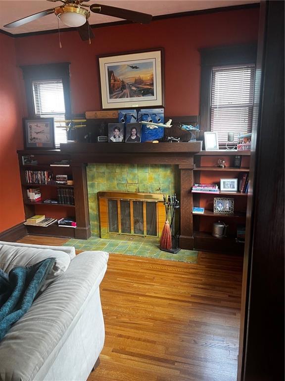 315 W 4th St, Ottawa, KS 66067 - living room featuring a fireplace, a ceiling fan, and wood finished floors