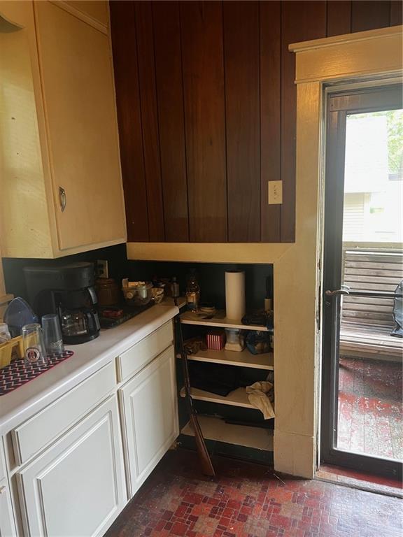 315 W 4th St, Ottawa, KS 66067 - kitchen with light countertops, brick flooring, and white cabinets