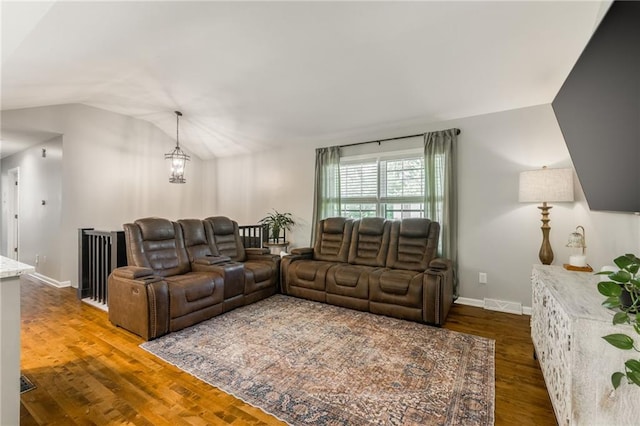 living room with lofted ceiling, a chandelier, dark wood-style flooring, and baseboards