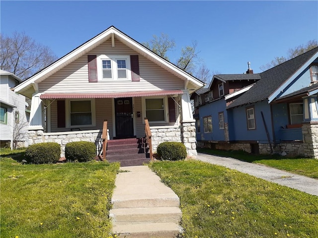 3637 Bales Ave, Kansas City, MO 64128 - bungalow-style house featuring a porch, stone siding, and a front yard