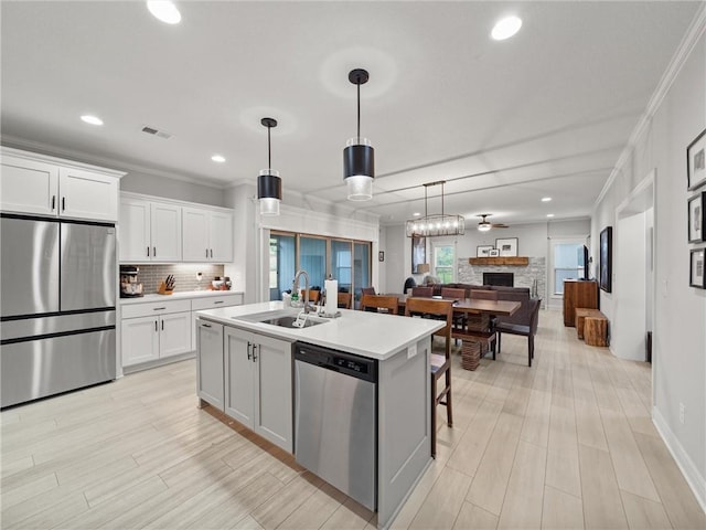 11382 S Longview Rd, Olathe, KS 66061 - kitchen with appliances with stainless steel finishes, backsplash, ornamental molding, open floor plan, and a center island with sink