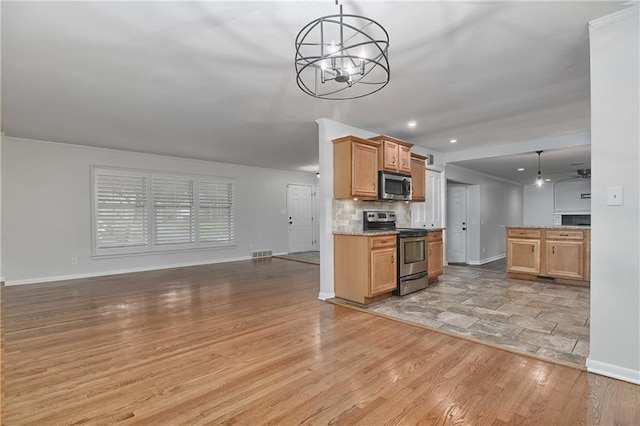 6411 Outlook Dr, Mission, KS 66202 - kitchen featuring appliances with stainless steel finishes, open floor plan, baseboards, a chandelier, and recessed lighting
