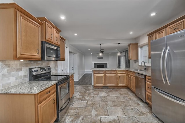6411 Outlook Dr, Mission, KS 66202 - kitchen featuring appliances with stainless steel finishes, a sink, ceiling fan, a peninsula, and decorative backsplash