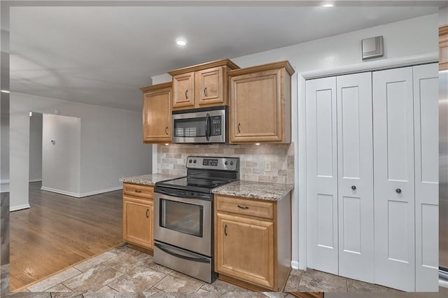 6411 Outlook Dr, Mission, KS 66202 - kitchen featuring stainless steel appliances, baseboards, tasteful backsplash, light stone countertops, and recessed lighting