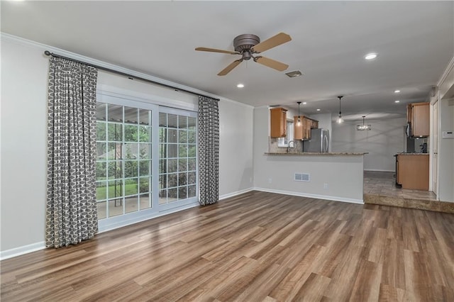 6411 Outlook Dr, Mission, KS 66202 - unfurnished living room featuring ornamental molding, wood finished floors, ceiling fan, baseboards, and recessed lighting