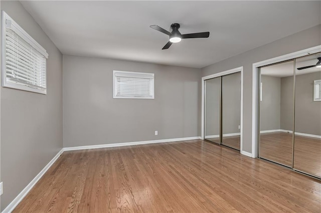 6411 Outlook Dr, Mission, KS 66202 - unfurnished bedroom with multiple closets, light wood-style floors, baseboards, and a ceiling fan