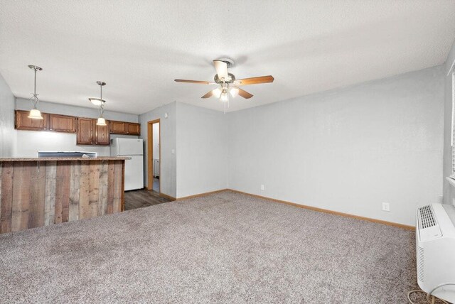 312 2nd St, Platte City, MO 64079 - unfurnished living room with baseboards, dark carpet, a ceiling fan, and a textured ceiling