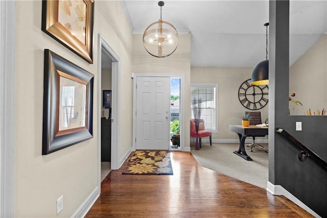 entryway featuring wood finished floors, a chandelier, and baseboards