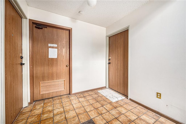 entrance foyer featuring a textured ceiling and baseboards