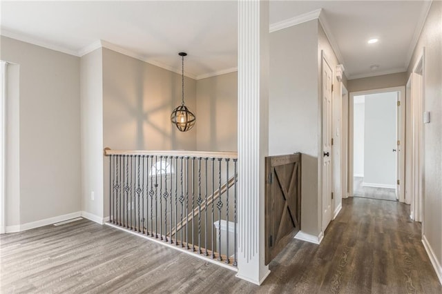 hall featuring wood finished floors, baseboards, and crown molding