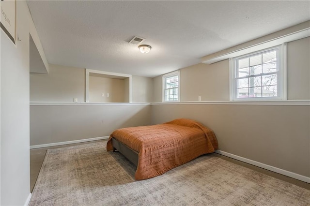 bedroom with a textured ceiling and baseboards