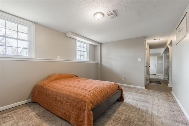 carpeted bedroom featuring baseboards and a textured ceiling