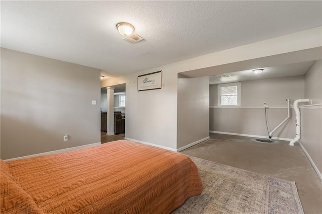 unfurnished bedroom with concrete floors, baseboards, and a textured ceiling