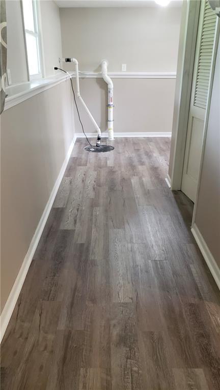 corridor with wood finished floors and baseboards