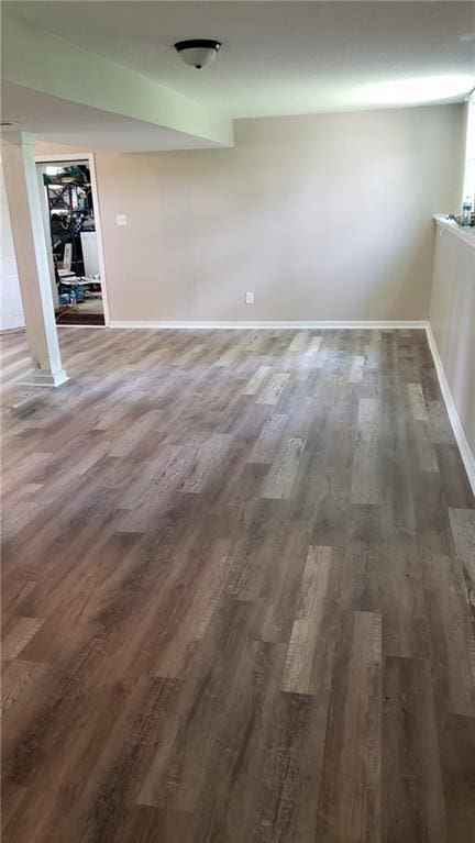spare room with baseboards and wood finished floors