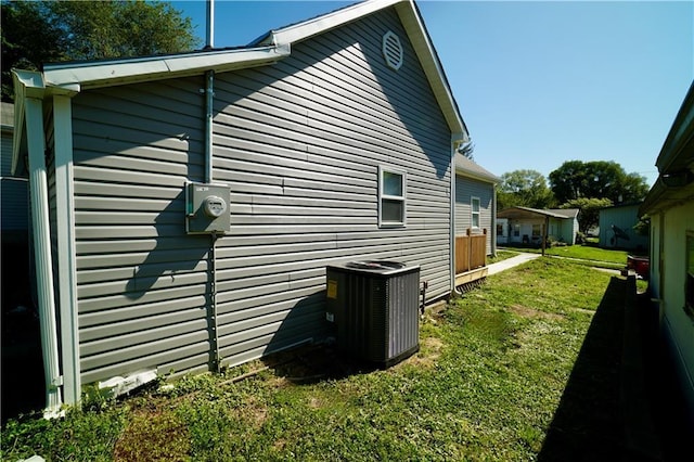 view of home's exterior with central air condition unit and a lawn
