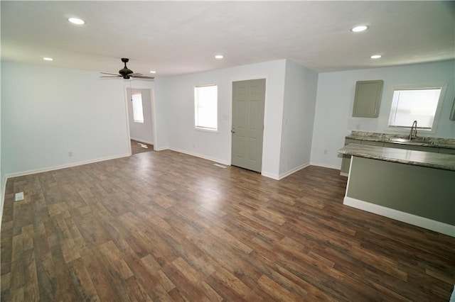 unfurnished living room featuring a sink, dark wood-style flooring, recessed lighting, a ceiling fan, and baseboards