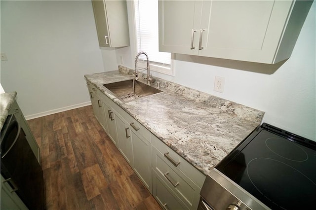 kitchen with a sink, electric stove, dark wood-style floors, baseboards, and light stone counters