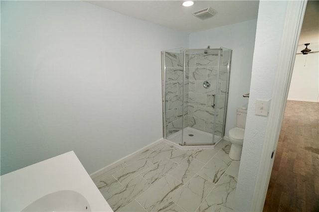 bathroom with toilet, baseboards, and a marble finish shower