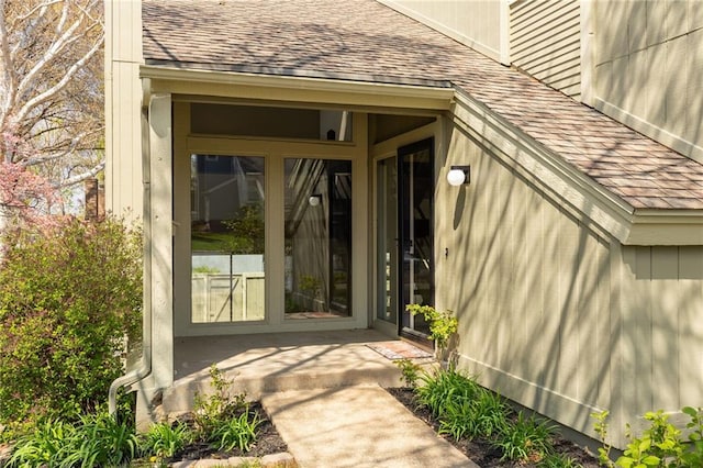 doorway to property with a shingled roof