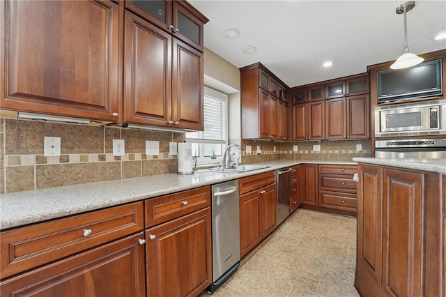 14927 S Caenen Ln, Olathe, KS 66062 - kitchen with appliances with stainless steel finishes, a sink, hanging light fixtures, decorative backsplash, and brown cabinetry