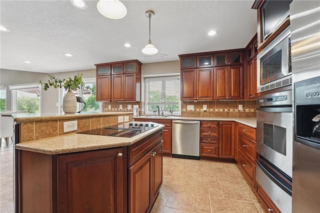14927 S Caenen Ln, Olathe, KS 66062 - kitchen with appliances with stainless steel finishes, a warming drawer, decorative backsplash, recessed lighting, and hanging light fixtures