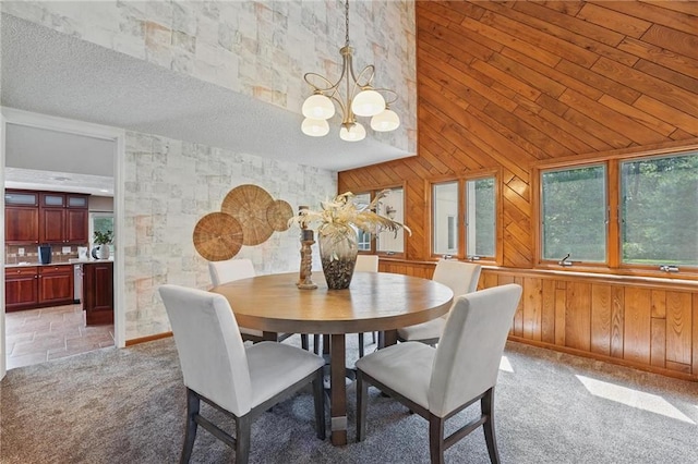 14927 S Caenen Ln, Olathe, KS 66062 - dining room featuring wood walls, a chandelier, light colored carpet, a high ceiling, and a textured ceiling