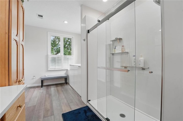 14927 S Caenen Ln, Olathe, KS 66062 - bathroom featuring a stall shower, wood finished floors, vanity, baseboards, and recessed lighting