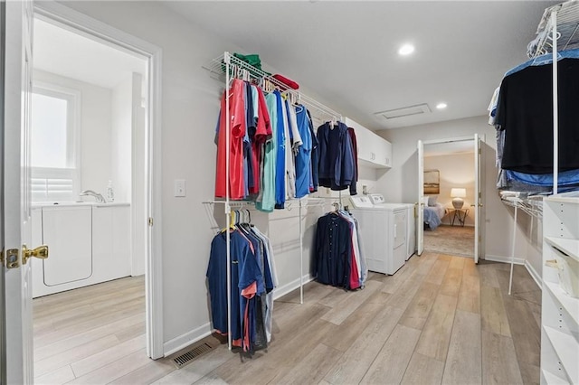 14927 S Caenen Ln, Olathe, KS 66062 - walk in closet featuring washing machine and clothes dryer and light wood finished floors