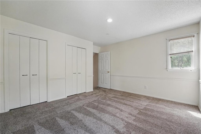 14927 S Caenen Ln, Olathe, KS 66062 - unfurnished bedroom with two closets, carpet flooring, a textured ceiling, recessed lighting, and baseboards