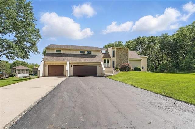 14927 S Caenen Ln, Olathe, KS 66062 - view of front of home featuring driveway, stucco siding, a front yard, and a garage