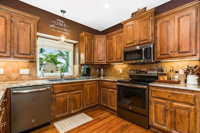 9008 N Hunter Ave, Kansas City, MO 64157 - kitchen featuring stainless steel appliances, a sink, wood finished floors, backsplash, and decorative light fixtures