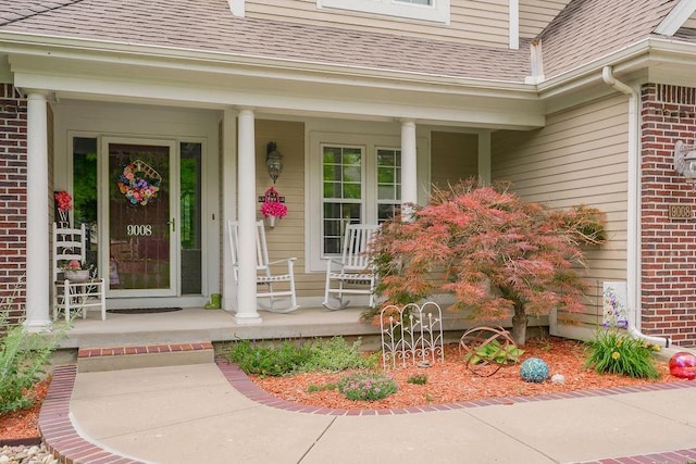 9008 N Hunter Ave, Kansas City, MO 64157 - entrance to property with covered porch, a shingled roof, and brick siding