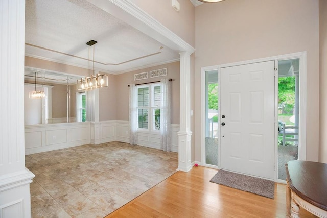 9008 N Hunter Ave, Kansas City, MO 64157 - entrance foyer featuring plenty of natural light, crown molding, a decorative wall, wainscoting, and wood finished floors
