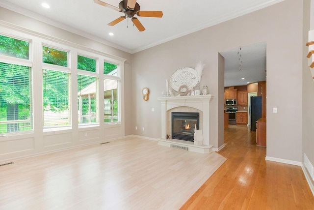9008 N Hunter Ave, Kansas City, MO 64157 - unfurnished living room featuring light wood-style flooring, a ceiling fan, crown molding, a tile fireplace, and recessed lighting