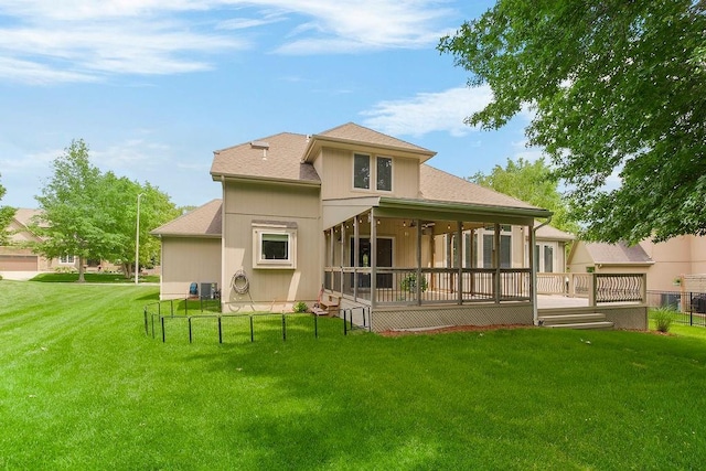 9008 N Hunter Ave, Kansas City, MO 64157 - rear view of property featuring a yard, a shingled roof, a deck, and a sunroom