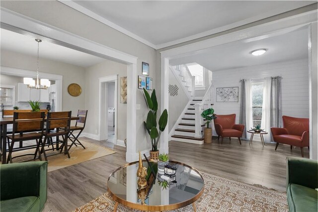 915 E 29th St, Kansas City, MO 64109 - living room with stairway, wood finished floors, a chandelier, and baseboards