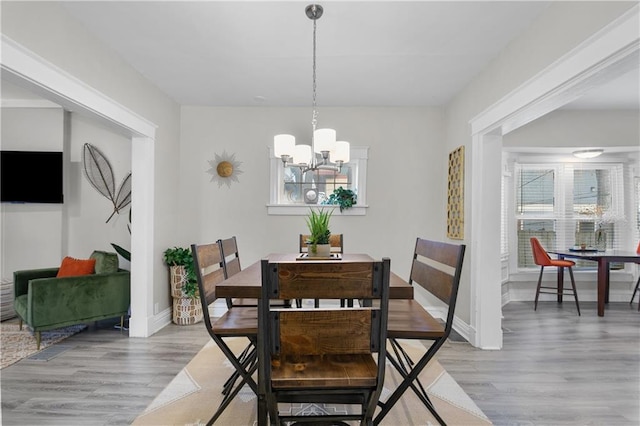 915 E 29th St, Kansas City, MO 64109 - dining space featuring a chandelier, light wood-style floors, and plenty of natural light