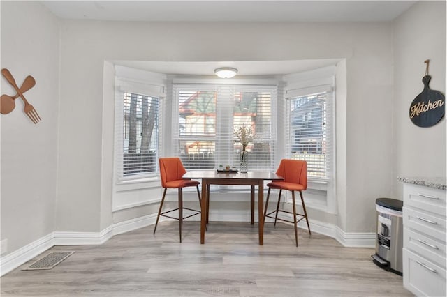 915 E 29th St, Kansas City, MO 64109 - dining space with light wood-type flooring and baseboards