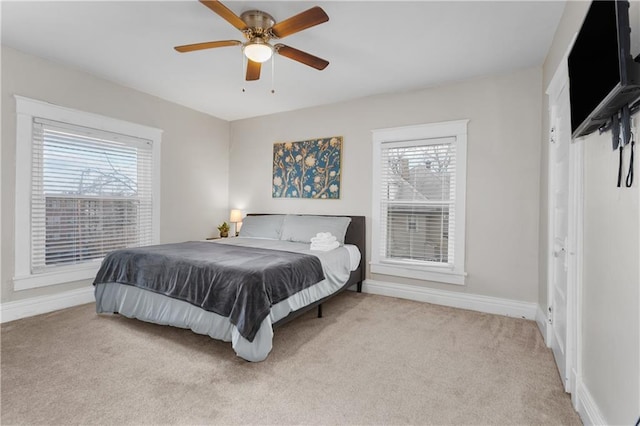 915 E 29th St, Kansas City, MO 64109 - carpeted bedroom featuring multiple windows, baseboards, and ceiling fan