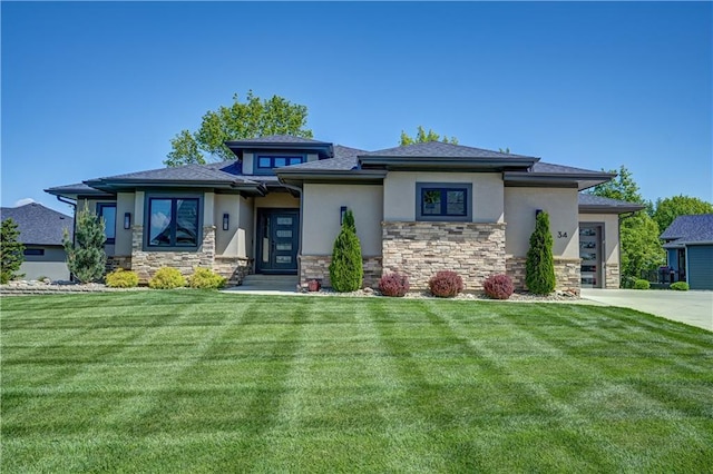 prairie-style house featuring stucco siding, a front lawn, stone siding, a garage, and concrete driveway