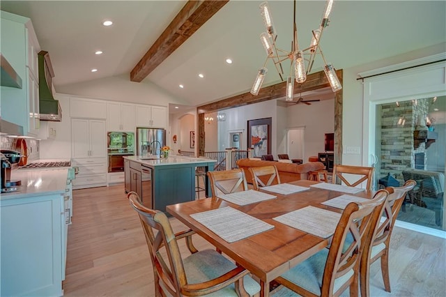 dining space with light wood-style floors, a ceiling fan, recessed lighting, arched walkways, and a chandelier