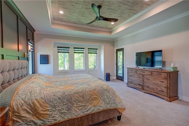 bedroom featuring a raised ceiling, multiple windows, light carpet, crown molding, and baseboards