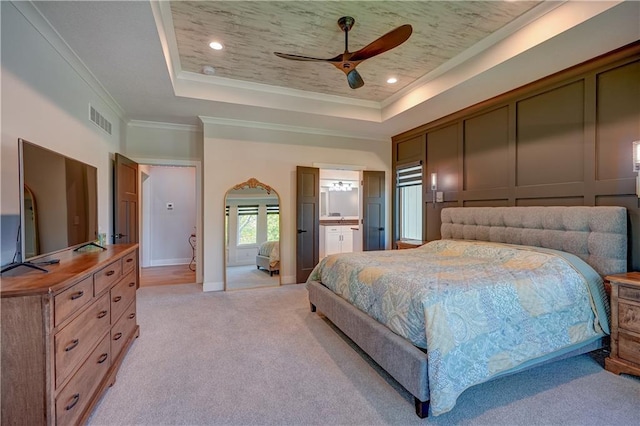 bedroom featuring a raised ceiling, light colored carpet, ornamental molding, baseboards, and a ceiling fan
