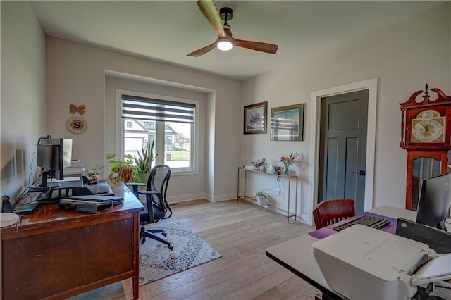 home office featuring ceiling fan, light wood-style flooring, and baseboards
