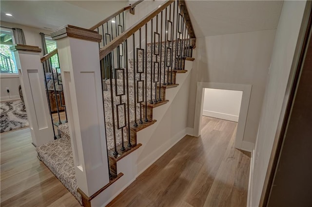 staircase with wood finished floors and baseboards
