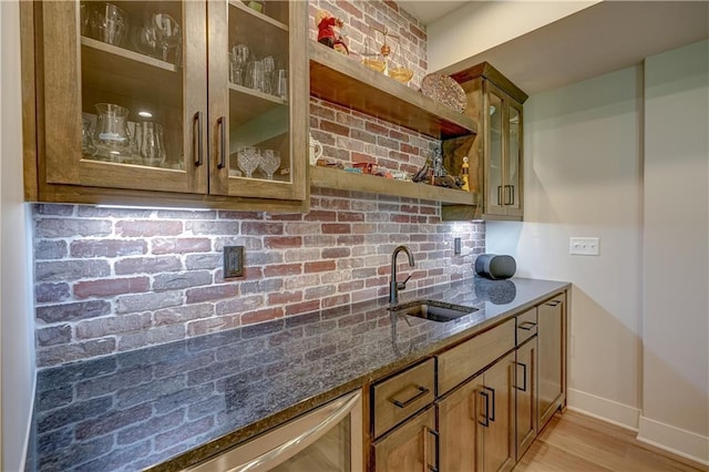 indoor wet bar featuring backsplash, baseboards, and light wood-style floors
