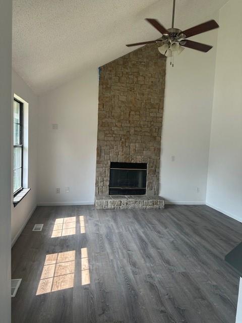 7037 N Holmes St, Gladstone, MO 64118 - unfurnished living room featuring lofted ceiling, a ceiling fan, wood finished floors, a fireplace, and baseboards