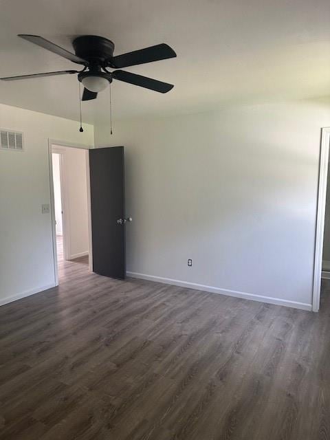7037 N Holmes St, Gladstone, MO 64118 - empty room with dark wood-style flooring, a ceiling fan, and baseboards