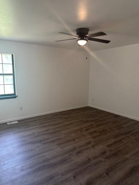 7037 N Holmes St, Gladstone, MO 64118 - unfurnished room with ceiling fan, dark wood-style flooring, and baseboards